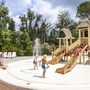 Kinder spielen auf einem Wasserspielplatz im Norcenni Girasole Village.