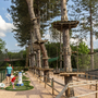 Ein Kletterpark in einem Wald mit hohen Plattformen und Seilen.