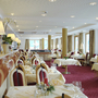Eleganter Speisesaal mit gedeckten Tischen und rotem Teppichboden.
