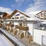 Hotel Amadeus Micheluzzi in Serfaus im Winter, Außenansicht mit verschneitem Dach.