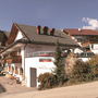Gebäudeansicht des Hotels Amadeus Micheluzzi in Serfaus mit umliegender Landschaft.