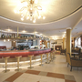 Moderne Hotellobby mit Bar, roten Hockern und gemütlichen Sitzbereichen.
