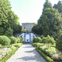 Villa inmitten eines gepflegten Parks mit auffälligen Hecken und Bäumen.