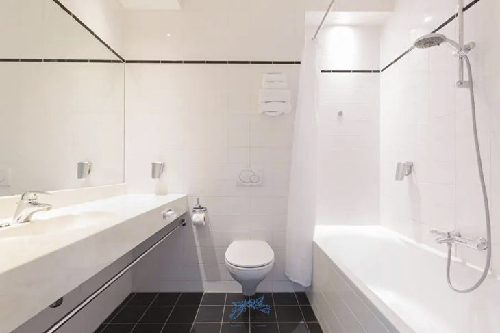 Modernes Hotelbad mit weißer Keramik, Badewanne und Dusche im Amrath Hotel Alkmaar.