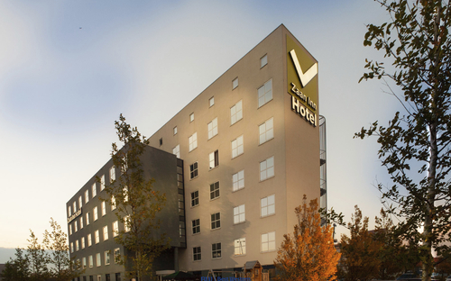 Außenansicht des Hotels Best Western Zaan Inn mit mehreren Etagen und Bäumen im Vordergrund.