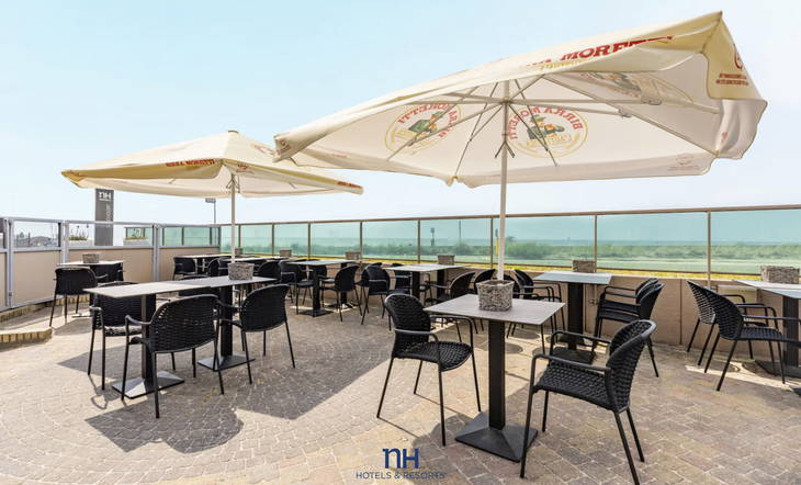 Hotelterrasse mit Tischen, Stühlen und Sonnenschirmen und Meerblick in Zandvoort.