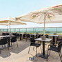 Hotelterrasse mit Tischen, Stühlen und Sonnenschirmen und Meerblick in Zandvoort.
