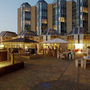 Terrasse des NH Hotels Zandvoort bei Abenddämmerung mit Sitzbereichen und Beleuchtung.
