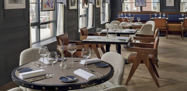 Restaurantbereich im Mövenpick Hotel Den Haag mit gedeckten Tischen und eleganter Einrichtung.