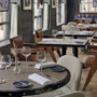 Restaurantbereich im Mövenpick Hotel Den Haag mit gedeckten Tischen und eleganter Einrichtung.