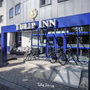 Eingangsbereich des Tulip Inn Hotels in Antwerpen mit blauen Elementen und Fahrrädern.