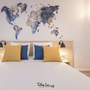 Modernes Hotelzimmer mit Doppelbett und Weltkarte an der Wand.