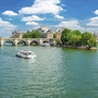 Blick auf die Seine mit Eiffelturm und Brücke in Paris bei sonnigem Wetter.