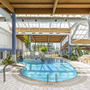 Innenansicht eines Hallenbads mit Pool und Liegen im IFA Schöneck Hotel.