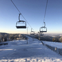 Sessellift über verschneiter Landschaft im Skiwelt Schöneck, blauer Himmel im Hintergrund