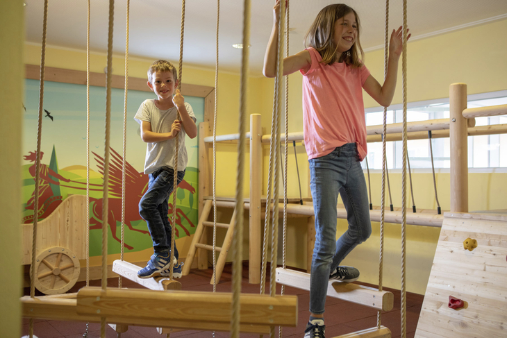 Kinder spielen lachend im Spielzimmer des JUFA Kempten Familien Resorts.
