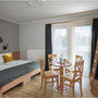 Hotelzimmer mit Doppelbett, Etagenbett und Tischgruppe im JUFA Kempten Familien-Resort
