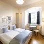 Helles Einzelzimmer im JUFA Hotel Kronach mit Bett, Fenster und Möbeln.