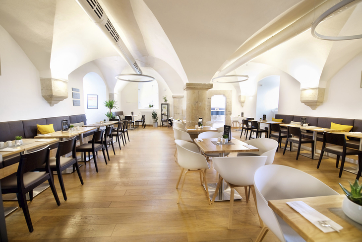 Helles Hotelrestaurant mit Holzböden und moderner Einrichtung.