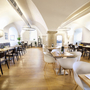 Helles Hotelrestaurant mit Holzböden und moderner Einrichtung.