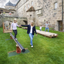 Mutter und Tochter spielen auf einem Spielplatz vor historischer Kulisse.
