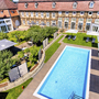 Außenansicht mit Pool und historischem Gebäude im Welcome Hotel Bad Arolsen.
