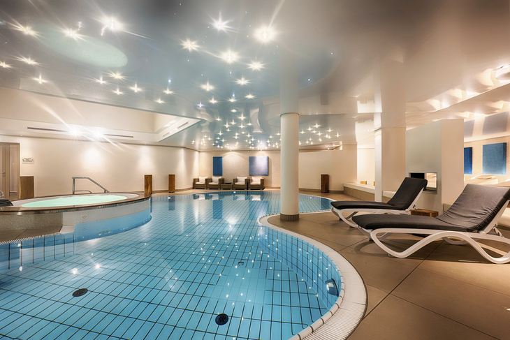 Innenpool mit Liegestühlen im Welcome Hotel Bad Arolsen Spa Bereich