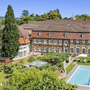Luftaufnahme eines historischen Gebäudes mit Pool und Garten im Welcome Hotel Bad Arolsen.