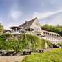 Außenansicht des Welcome Hotel Meschede mit Terrasse und grüner Umgebung.