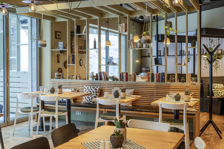 Modern eingerichtetes Hotelrestaurant mit Holztischen und Stühlen.