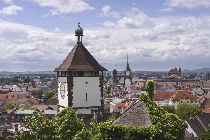 Aussicht auf Freiburg mit historischem Turm und umliegender Stadtlandschaft.