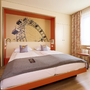 Doppelzimmer im JUFA Hotel Wien City mit modernem Dekor und großem Wandbild.