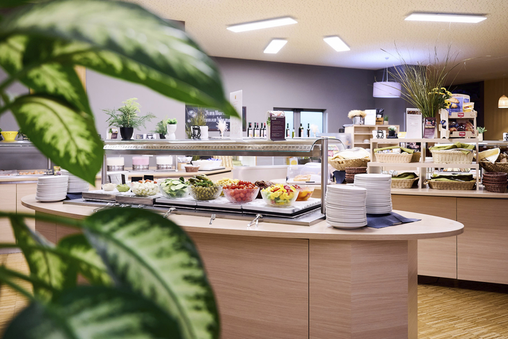 Buffetbereich im JUFA Hotel Wien City mit verschiedenen Speisen und Pflanzen im Vordergrund