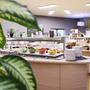 Buffetbereich im JUFA Hotel Wien City mit verschiedenen Speisen und Pflanzen im Vordergrund