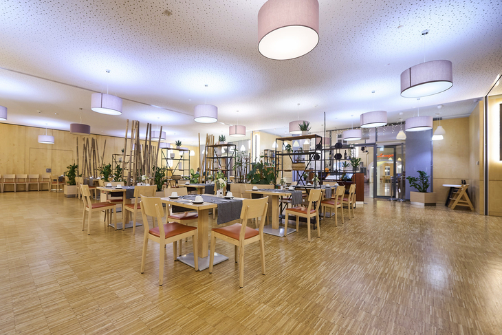 Modern eingerichteter Frühstücksraum im JUFA Hotel Wien City mit hellen Holzmöbeln.