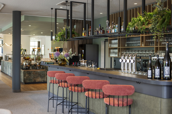 Barbereich des JUFA Hotels in Werfenweng mit Sitzgelegenheiten und Pflanzen.