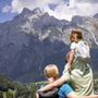 Personen blicken auf eine Berglandschaft in Werfenweng.