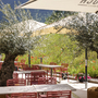 Terrasse des JUFA Hotels in Werfenweng mit Tischen, Stühlen und Sonnenschirmen.