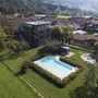 Luftaufnahme eines Hotels mit Pool in grüner Landschaft bei Lenzumo.