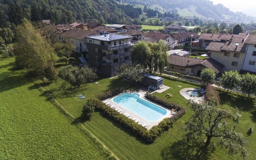 Luftaufnahme eines Hotels mit Pool in grüner Landschaft bei Lenzumo.