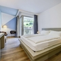 Hotelzimmer mit Doppelbett, Holzboden und Bergblick durch ein Fenster.