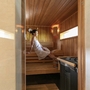 Frau entspannt in einer Sauna mit Holzwänden.