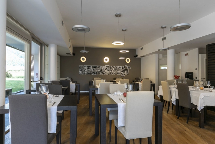 Restaurant mit modernen Möbeln und gedeckten Tischen in einem hellen Raum.