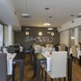 Restaurant mit modernen Möbeln und gedeckten Tischen in einem hellen Raum.