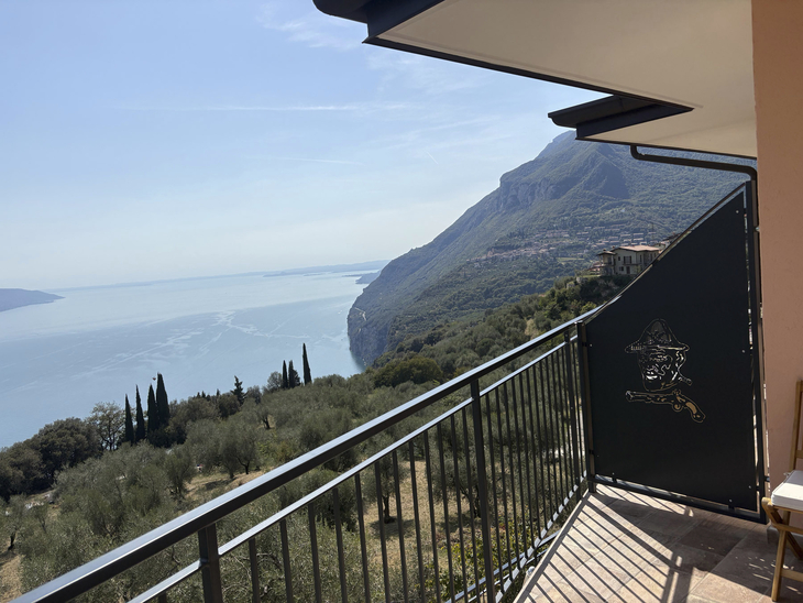Blick von einem Balkon auf den Gardasee und Hügel in Tignale, Italien.