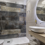 Modernes Badezimmer im Park Hotel Zanzanu mit großer Dusche und elegantem Waschbecken.