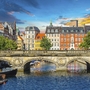 Brücke über einen Kanal in Kopenhagen vor bunten Gebäuden.