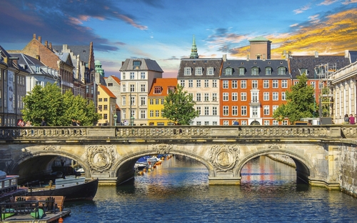 Brücke über einen Kanal in Kopenhagen vor bunten Gebäuden.