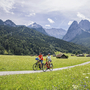 Radfahrerpaar auf ländlichem Weg vor Alpenpanorama in Garmisch