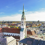 Blick auf die Kirche St. Peter in der Münchner Innenstadt unter blauem Himmel.